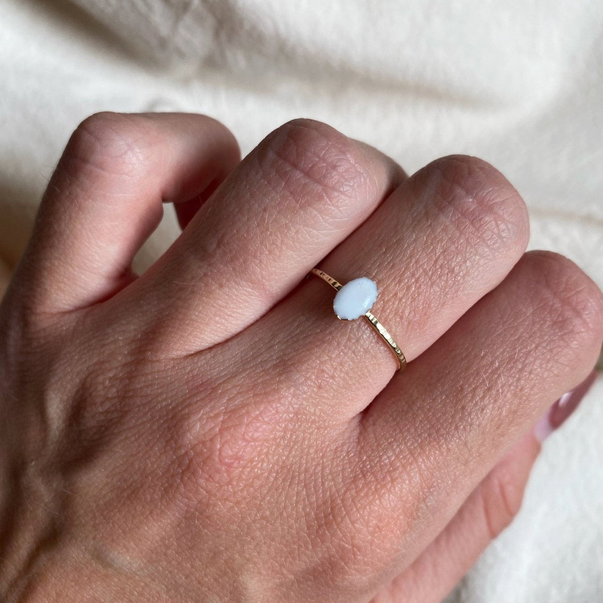 Handgemaakte ring met een moedermelksteen, gedragen aan de hand